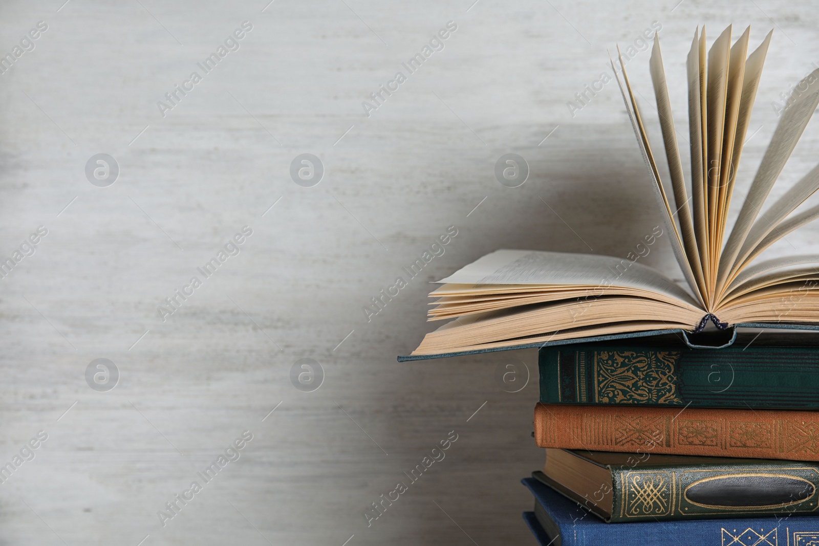 Photo of Stack of hardcover books on white wooden background. Space for text