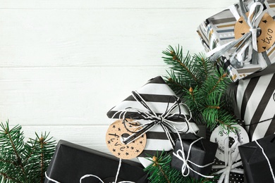 Photo of Gift boxes and fir branches on white wooden table, flat lay with space for text. Christmas advent calendar