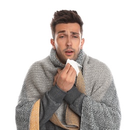 Photo of Young man wrapped in warm blanket suffering from cold on white background