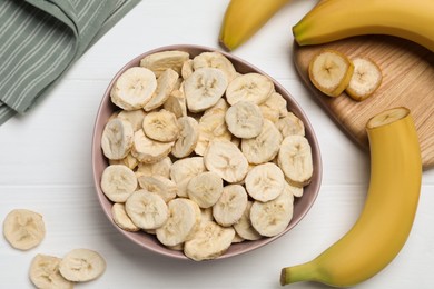 Photo of Freeze dried and fresh bananas on white wooden table, flat lay