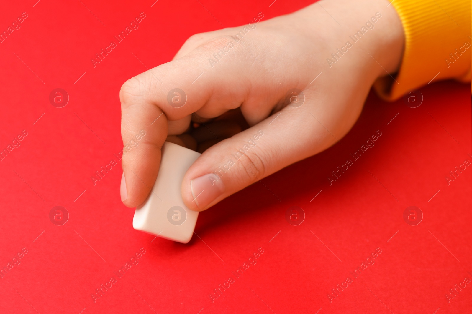 Photo of Man erasing something on red background, closeup