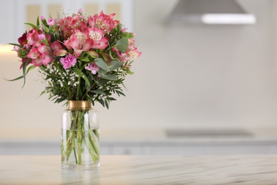 Photo of Vase with beautiful alstroemeria flowers on table in kitchen, space for text. Interior design