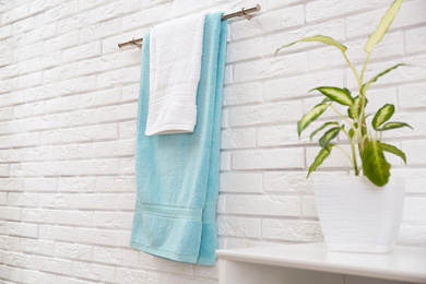 Photo of Fresh clean towels on hanger in bathroom