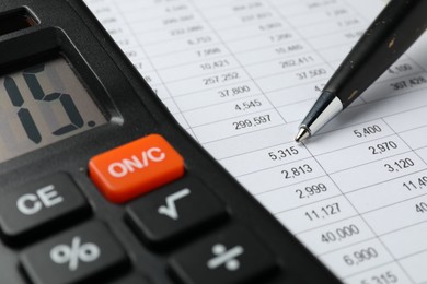 Photo of Calculator and pen on document with financial calculations, closeup