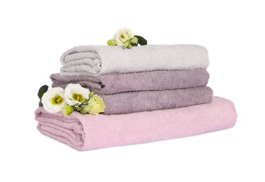 Photo of Stack of clean soft towels with flowers isolated on white