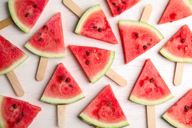 Photo of Slices of ripe watermelon on white wooden table, flat lay