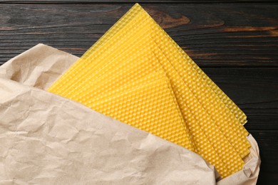 Photo of Natural organic beeswax sheets on wooden table, flat lay
