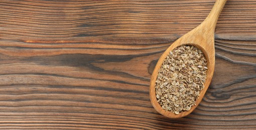 Image of Dill seeds in spoon on wooden table, top view. Banner design with space for text