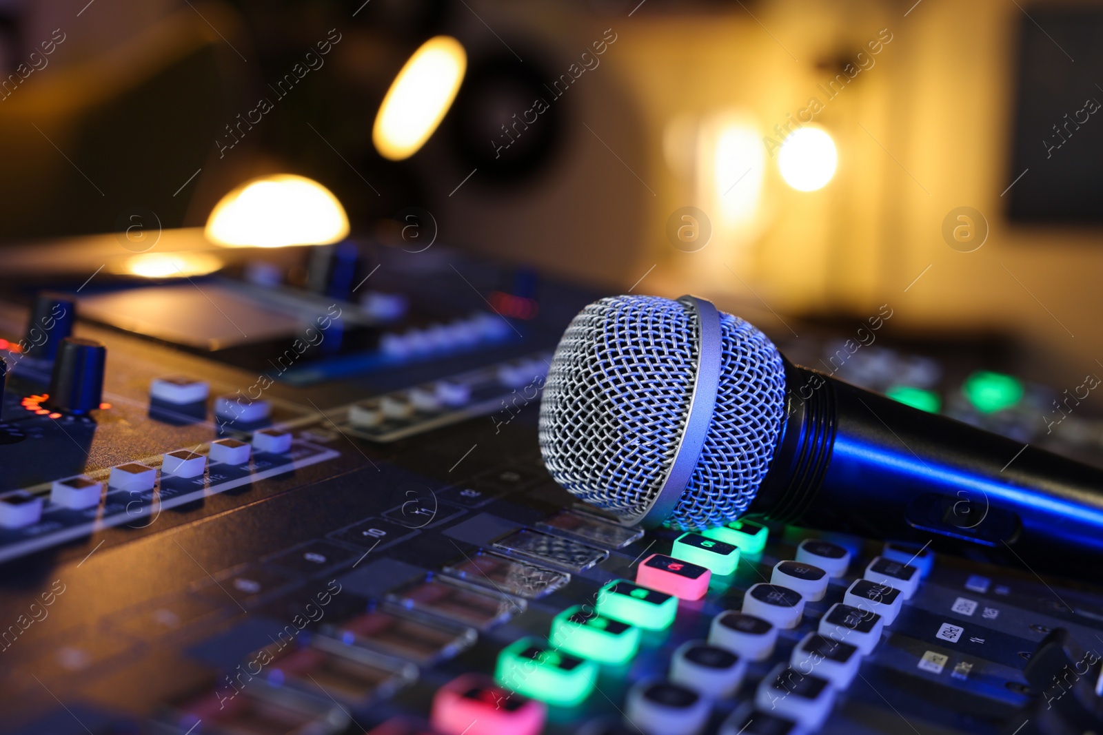 Photo of Microphone on professional mixing console in radio studio, closeup