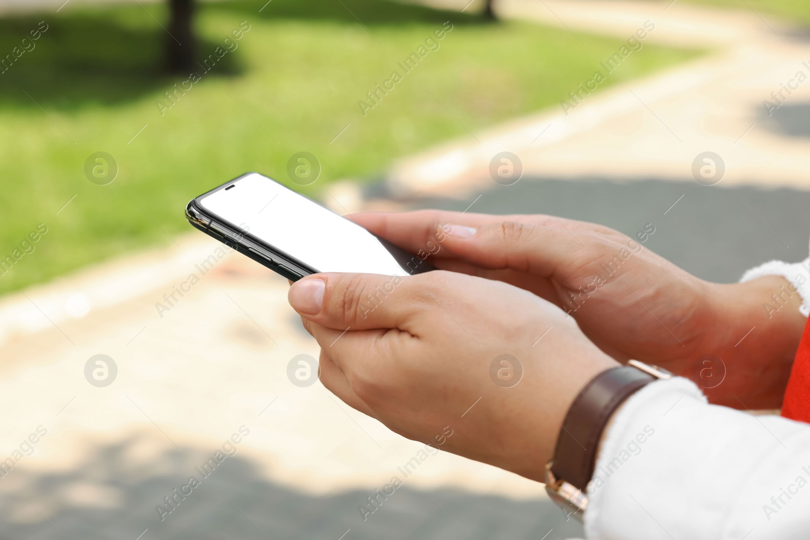 Photo of Woman with smartphone on walkway outdoors, closeup view