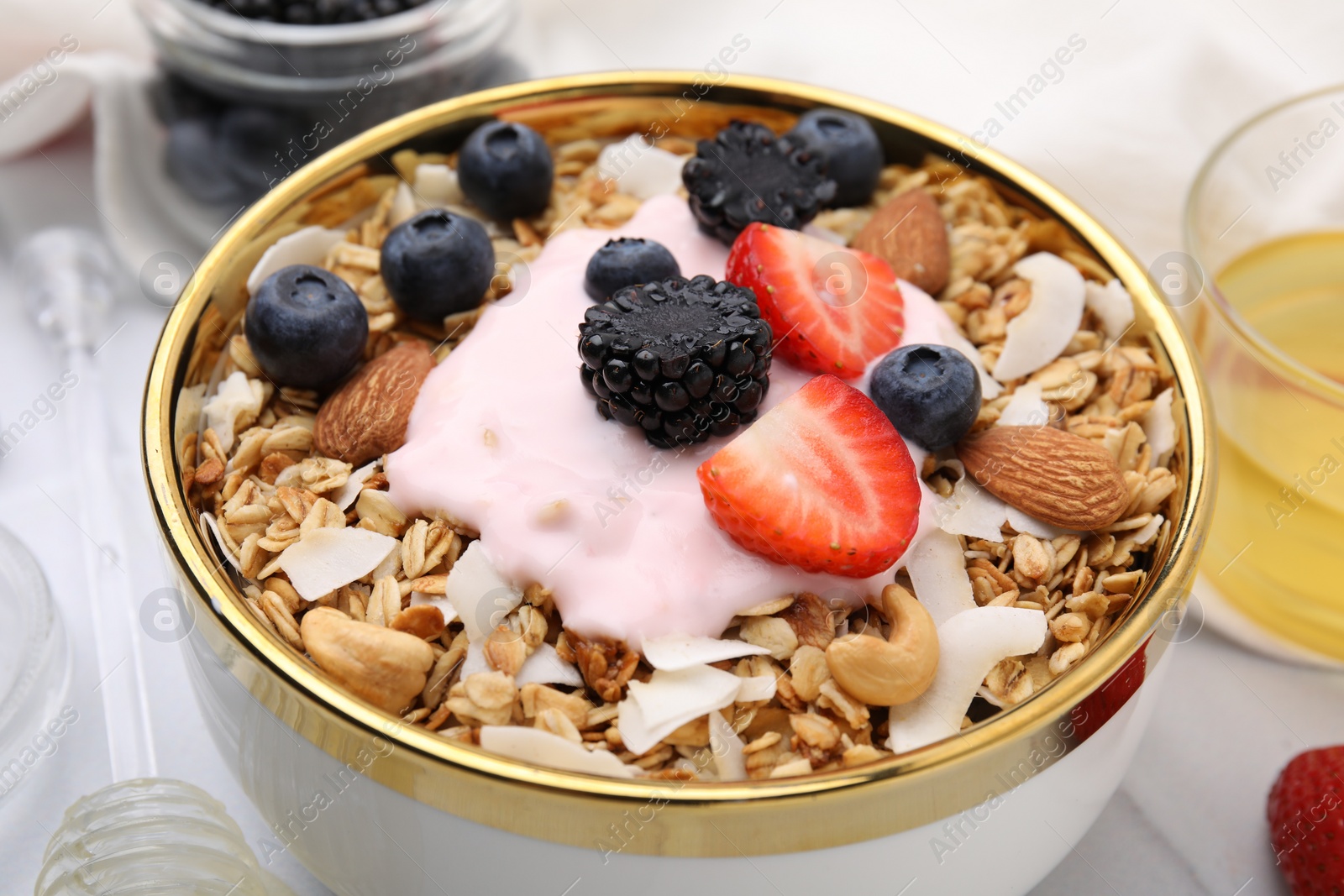 Photo of Tasty granola, yogurt and fresh berries in bowl on table, closeup. Healthy breakfast