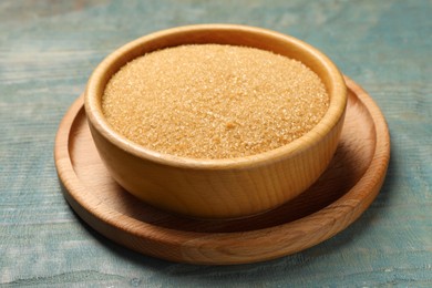 Photo of Brown sugar in bowl on light blue wooden table