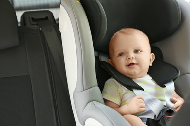 Photo of Little baby in child safety seat inside of car