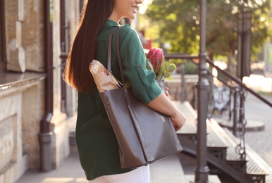 Photo of Woman with leather shopper bag near building, closeup