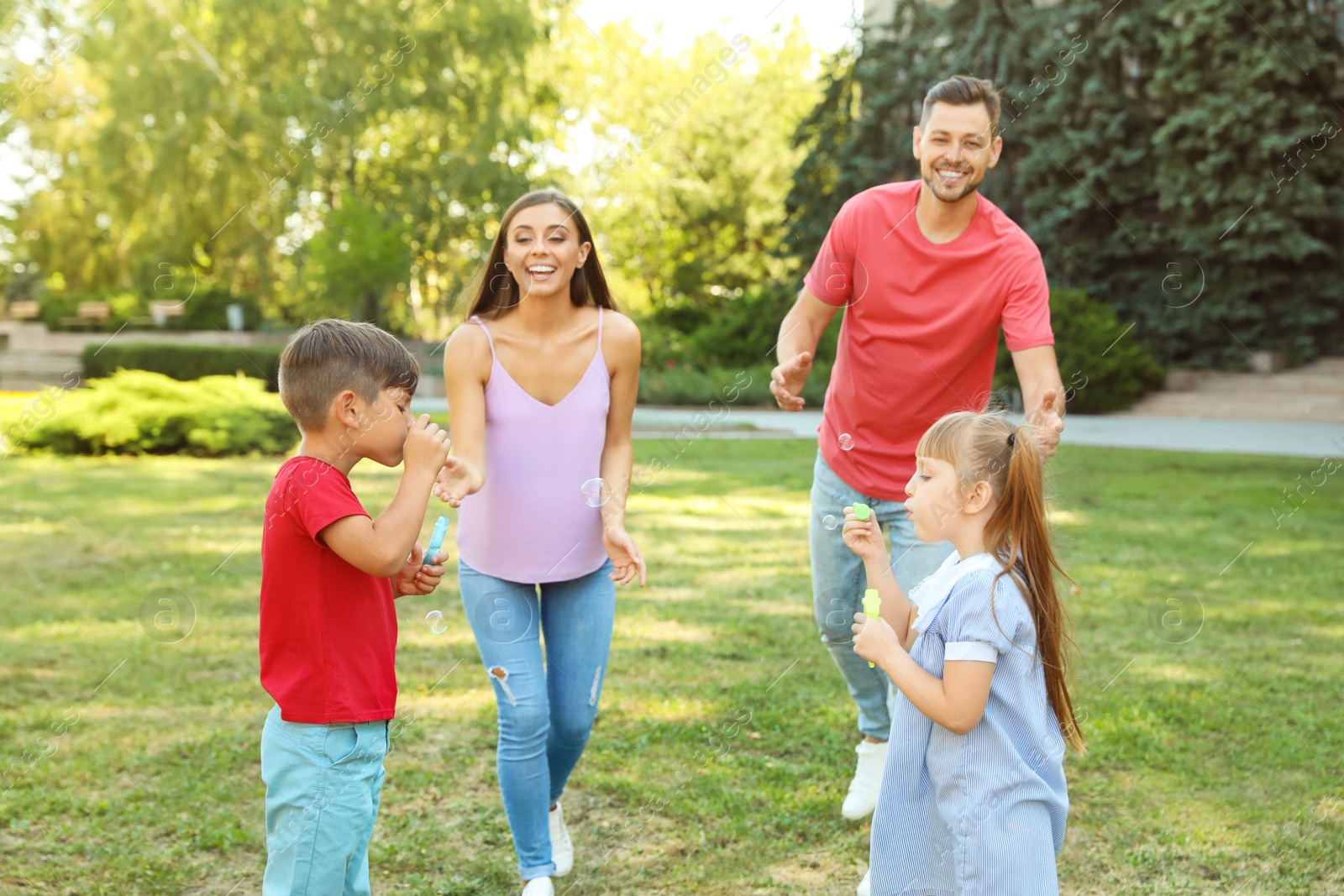 Photo of Happy family with children spending time together in green park on sunny day