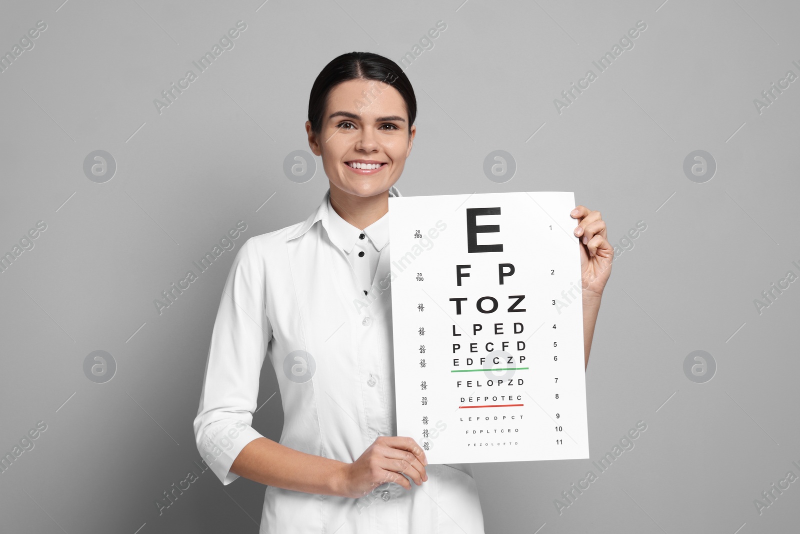 Photo of Ophthalmologist with vision test chart on gray background