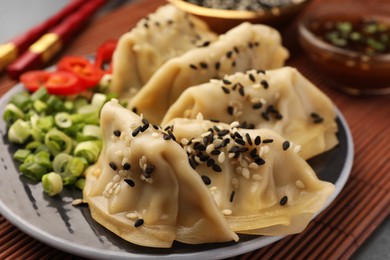 Delicious gyoza (asian dumplings) with sesame seeds on table, closeup