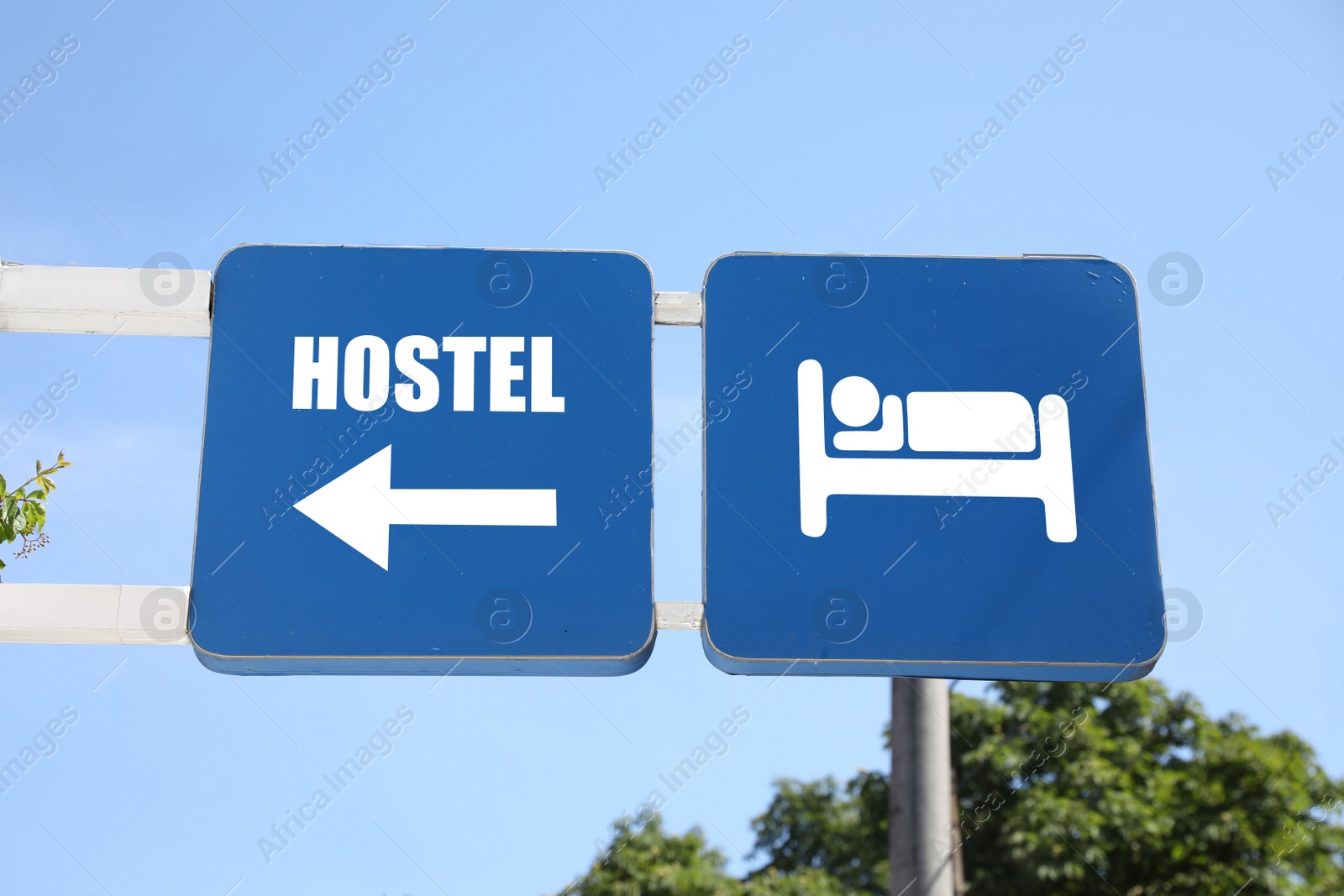 Image of HOSTEL sign boards against blue sky on sunny day