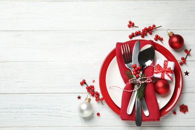 Beautiful Christmas table setting and festive decor on white wooden background, flat lay. Space for text