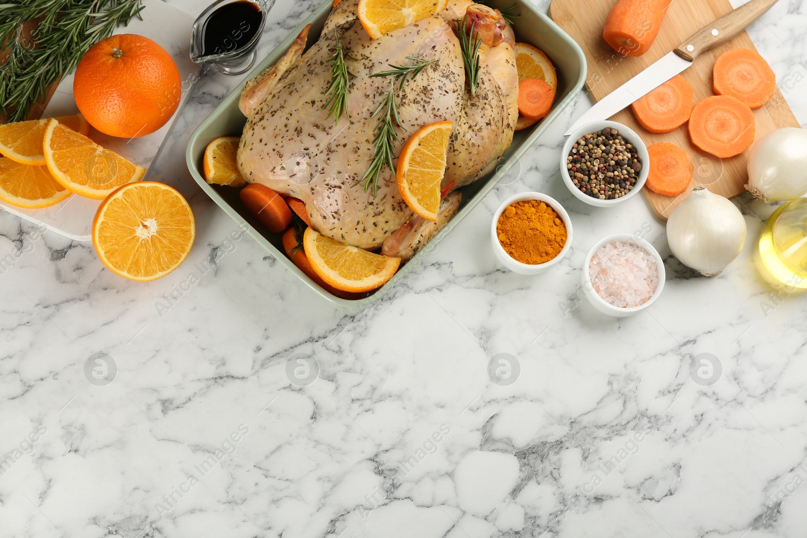 Photo of Raw chicken, orange slices and other ingredients on white marble table, flat lay. Space for text