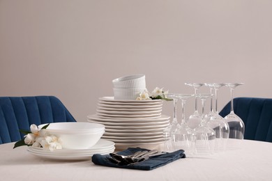 Photo of Set of clean dishware, cutlery and wine glasses on table indoors