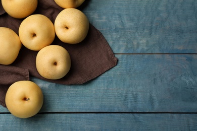 Photo of Ripe apple pears on blue wooden table, flat lay. Space for text