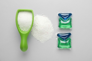 Photo of Laundry capsules and detergent powder on light grey background, flat lay