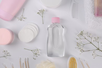 Photo of Baby oil in bottle, accessories and gypsophila on white background, flat lay