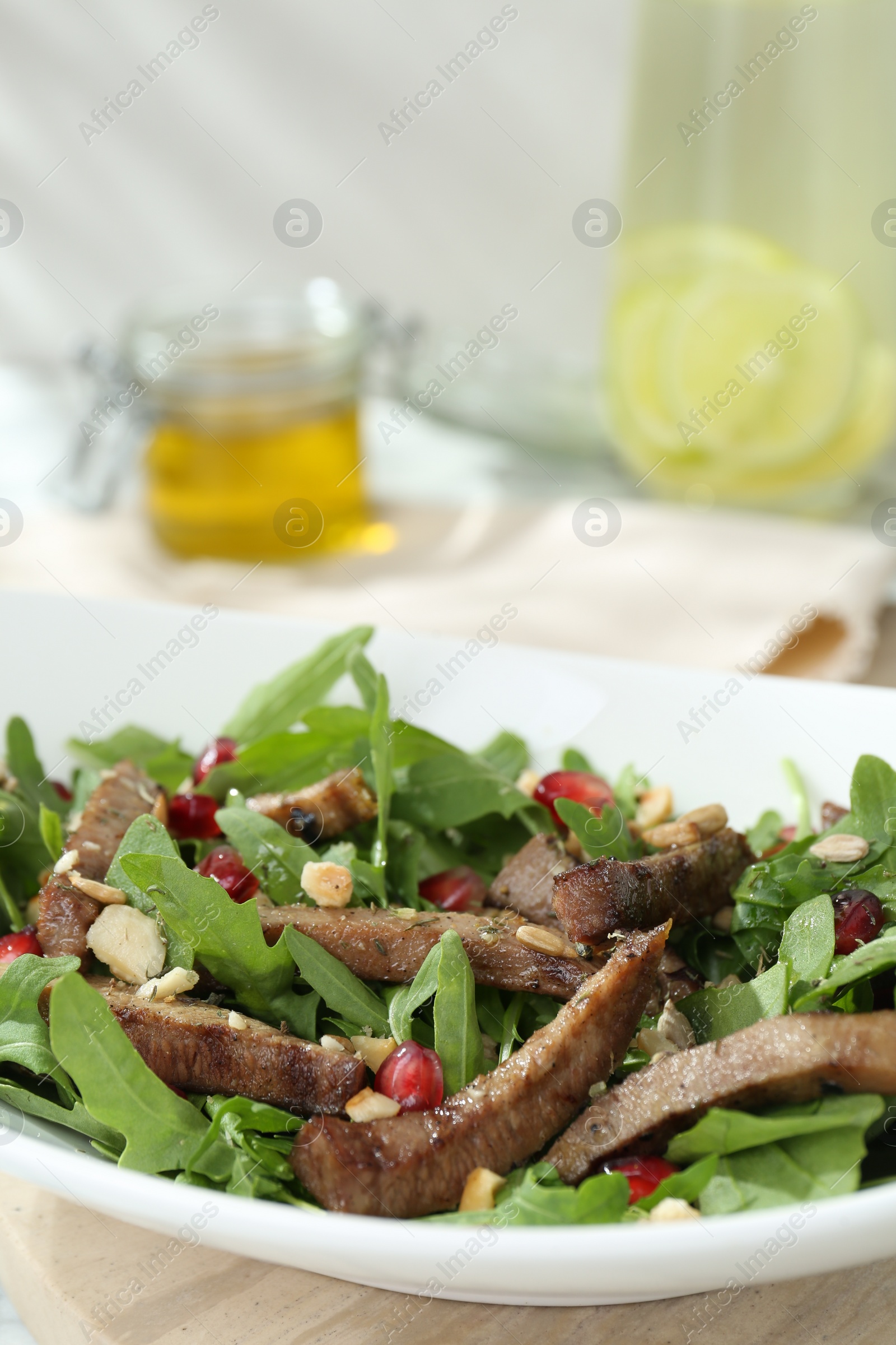 Photo of Delicious salad with beef tongue, arugula and seeds on table