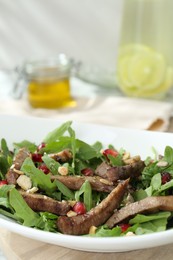 Delicious salad with beef tongue, arugula and seeds on table