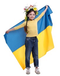 Photo of Little girl in flower wreath with flag of Ukraine on white background