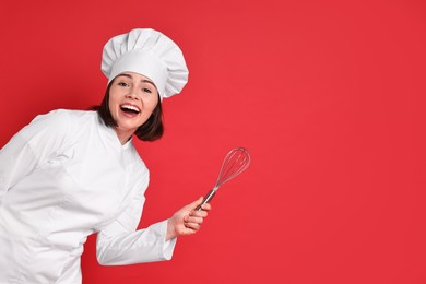 Happy confectioner holding whisk on red background, space for text