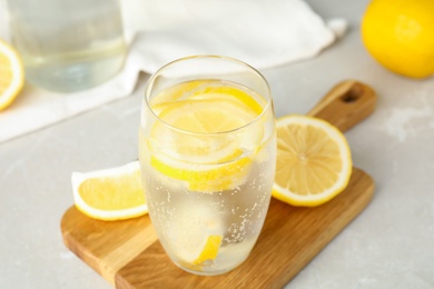 Soda water with lemon slices on light table