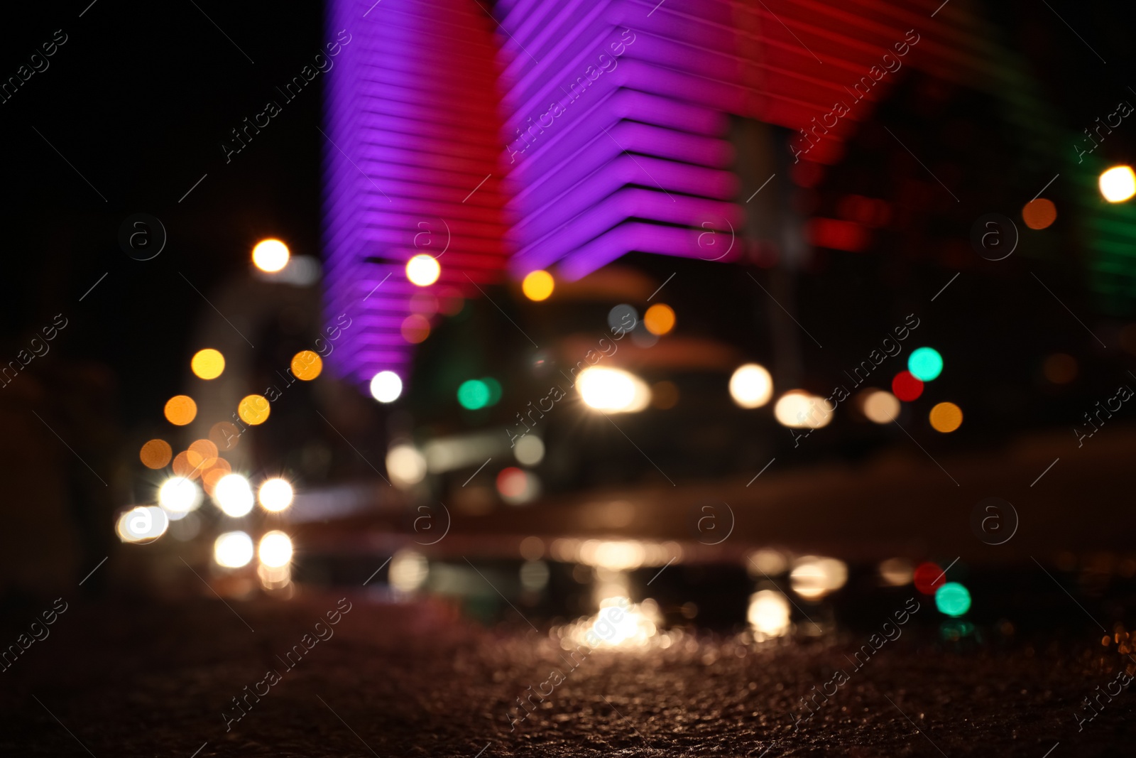 Photo of View of cityscape with bokeh effect, focus on asphalt. Night life