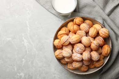 Photo of Bowl of delicious nut shaped cookies on grey table, flat lay. Space for text