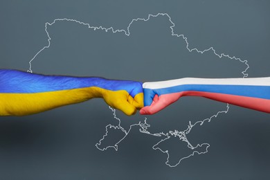 Image of Russian-Ukrainian war. People hitting each other with hands painted in colors of Ukrainian and Russian flags against outline map of Ukraine, closeup