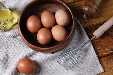 Metal whisk, raw eggs in bowl and spices on table, flat lay