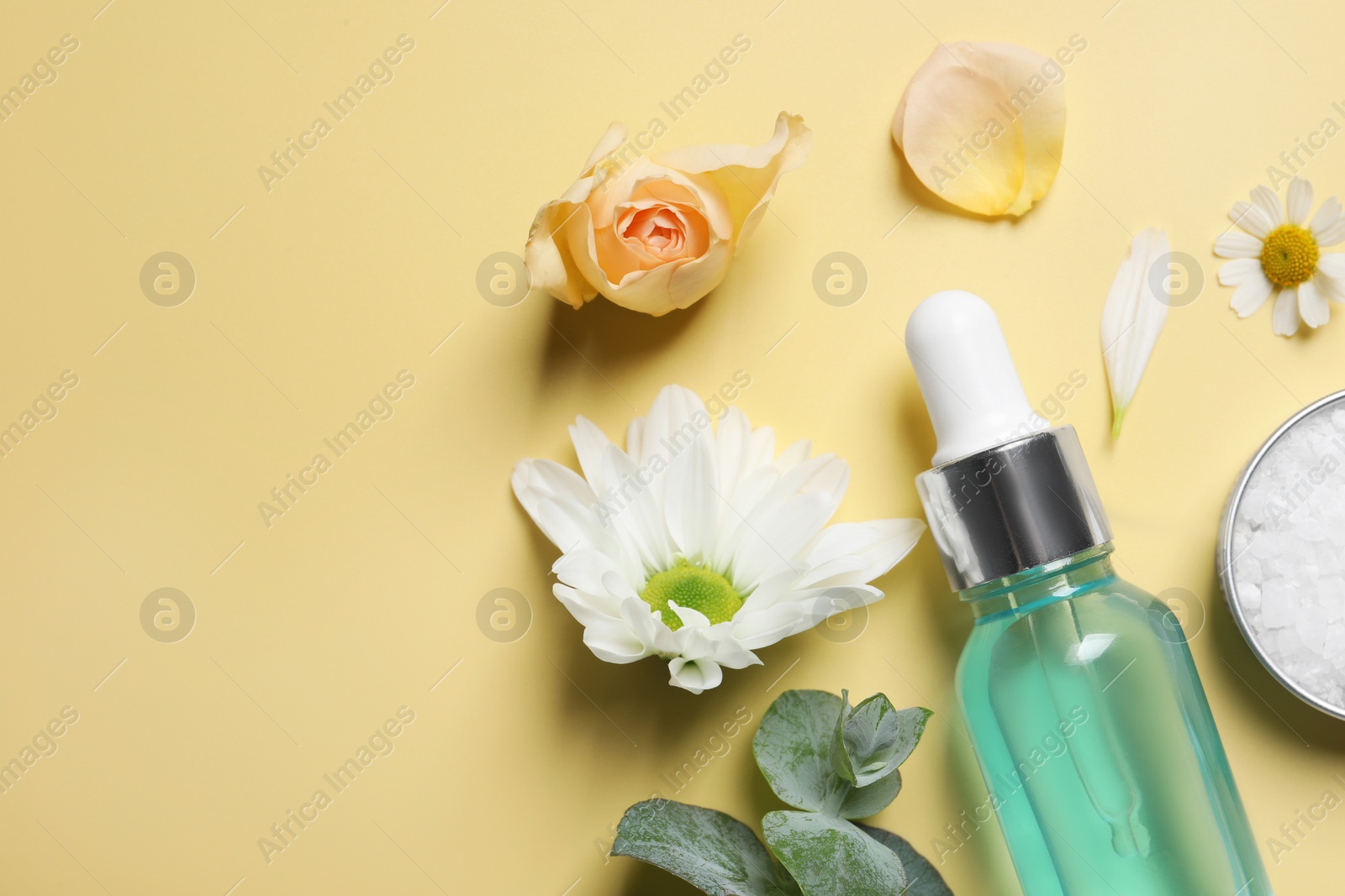 Photo of Flat lay composition with cosmetic serum on pale yellow background. Space for text