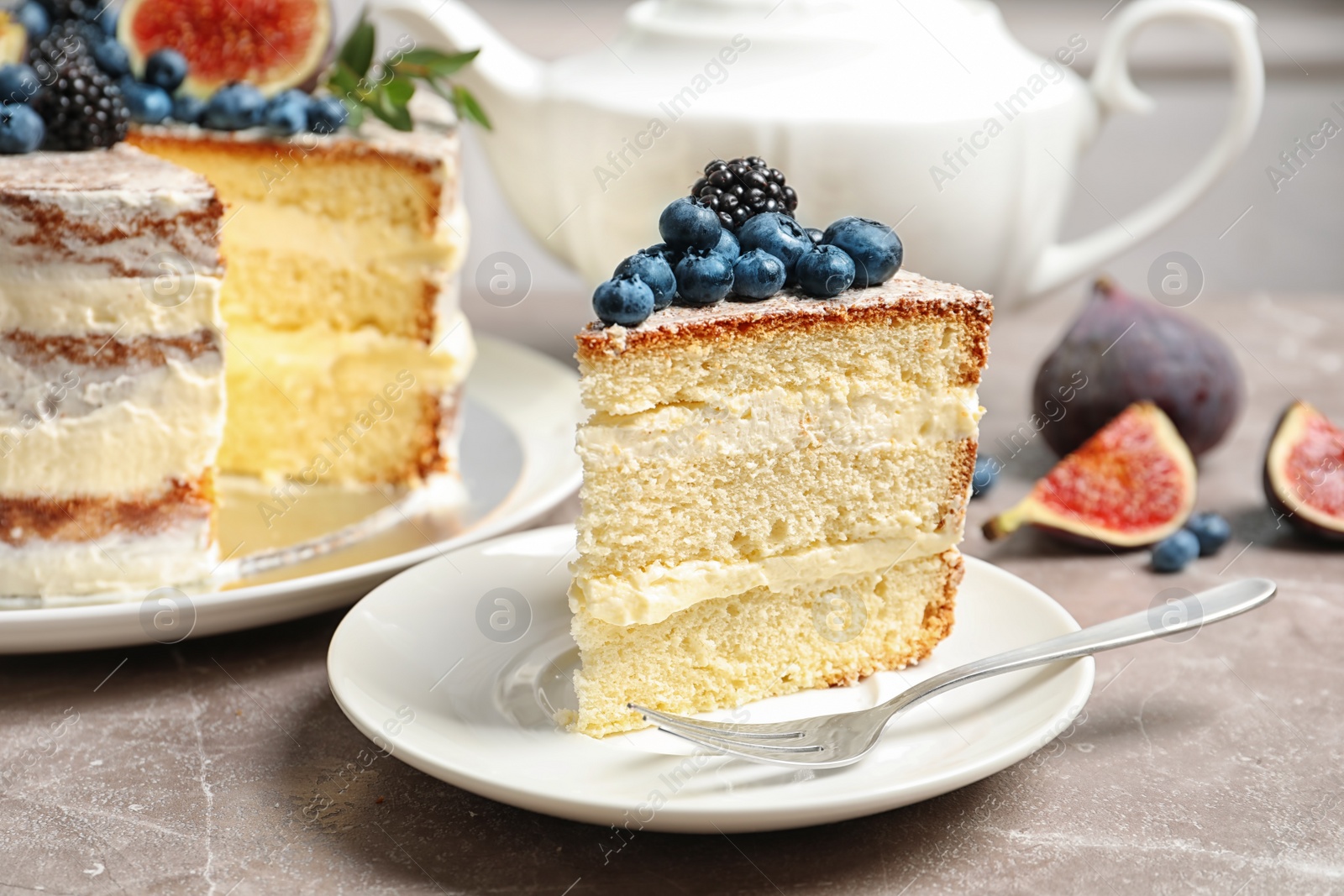 Photo of Piece of delicious homemade cake with fresh berries served on table