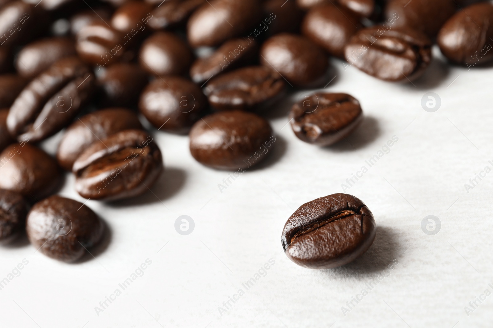 Photo of Roasted coffee beans on white background, closeup