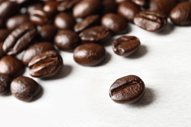 Photo of Roasted coffee beans on white background, closeup