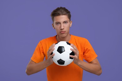 Photo of Sports fan with soccer ball on purple background