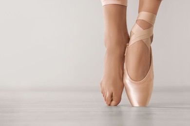 Photo of Ballerina in pointe shoe dancing indoors, closeup. Space for text