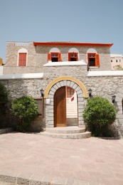 Beautiful house exterior with shrubbery on sunny day