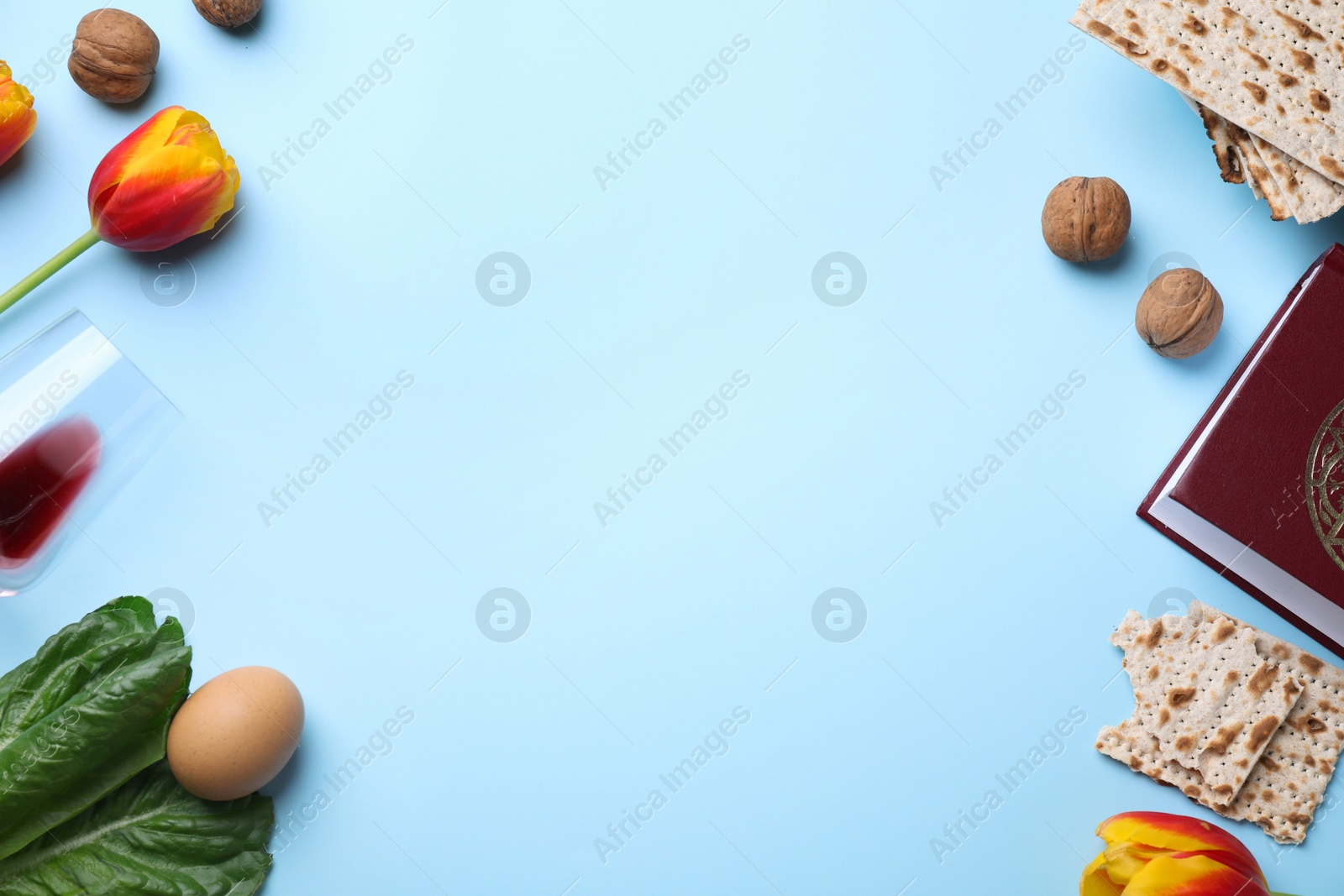 Photo of Flat lay composition with symbolic Pesach (Passover Seder) items on light blue background, space for text