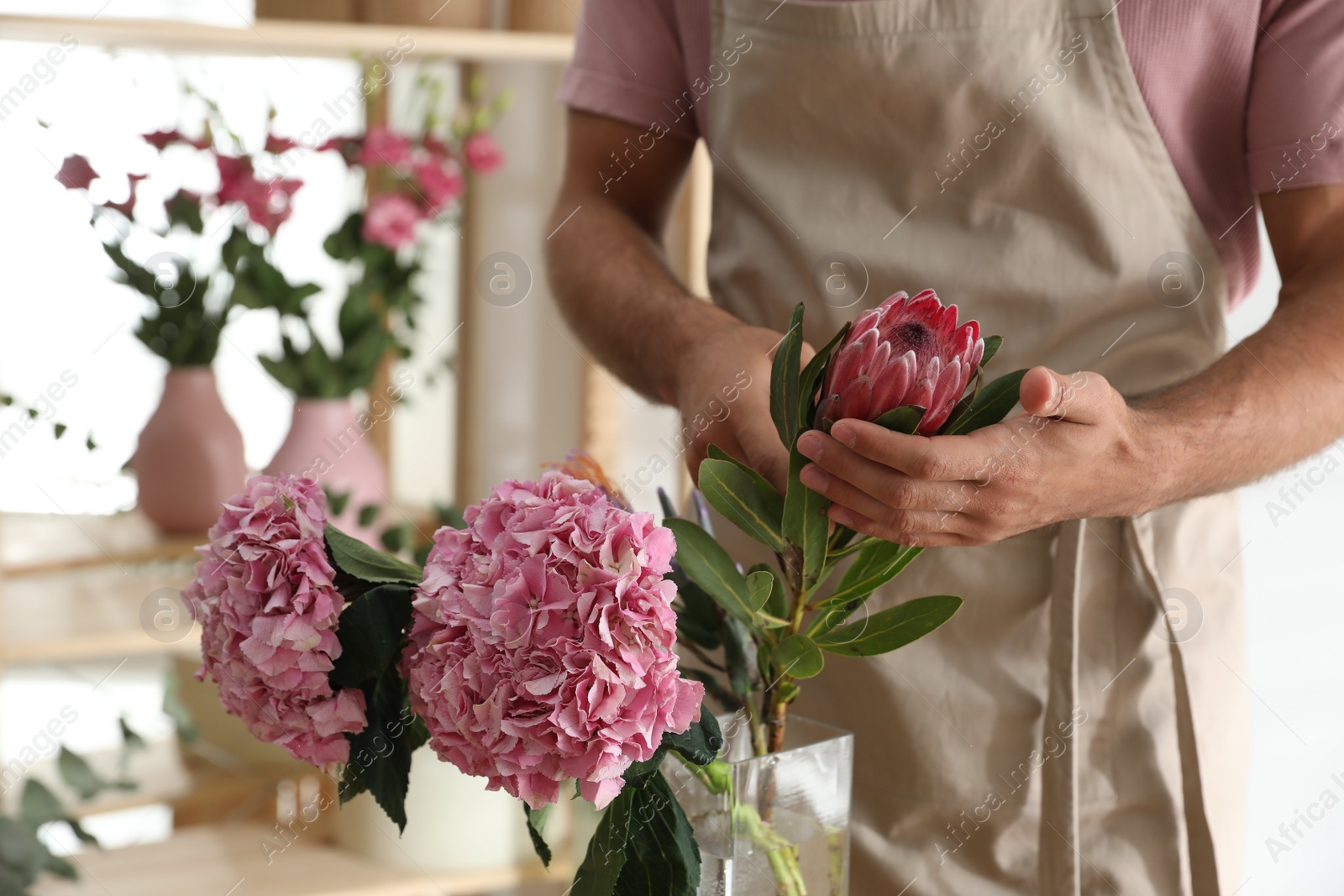 Photo of Florist with beautiful flowers in workshop, closeup