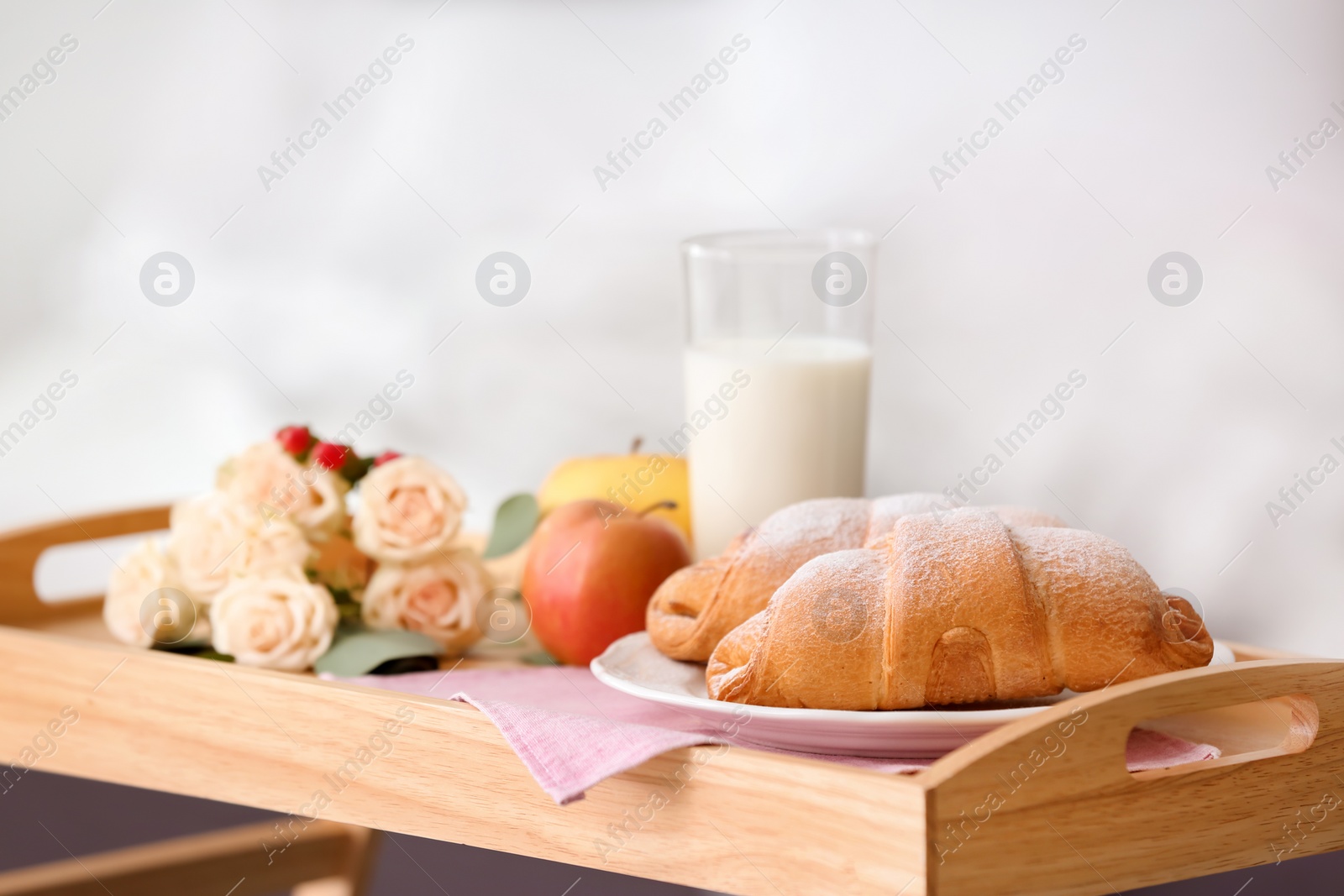 Photo of Tray with delicious croissants, milk and apples indoors