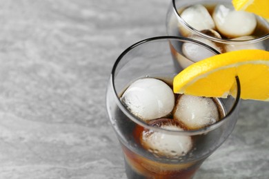 Delicious cocktail with orange and ice balls on grey table, closeup. Space for text