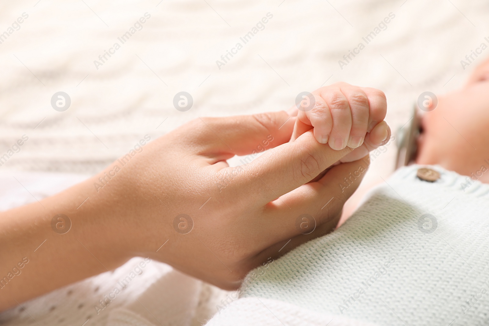 Photo of Mother and her newborn baby on bed, closeup view