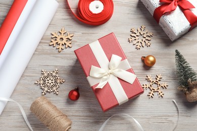 Photo of Flat lay composition with beautiful Christmas gift boxes and wrapping paper on white wooden table